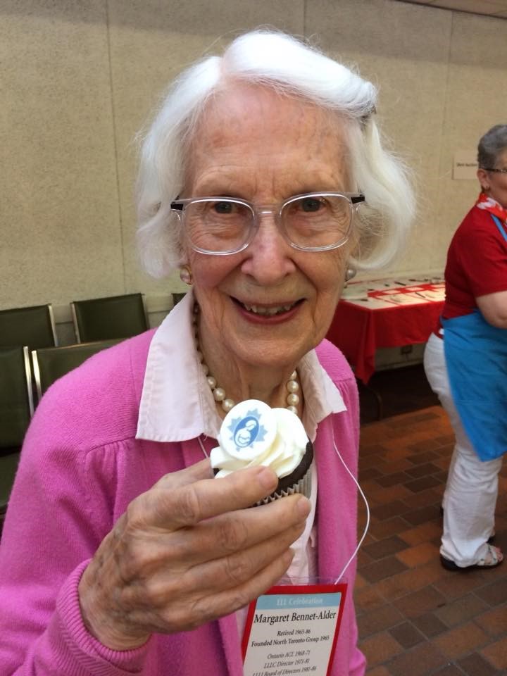 Margaret Bennet-Alder celebrating her 90th birthday with fellow La Leche League Leaders holding a cupcake